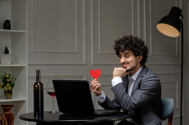 Virtual love handsome cute guy in suit with wine on a distance computer date talking thinking