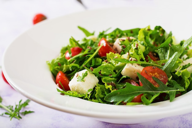 Vitamin Salad of fresh tomatoes, herbs, feta cheese and flax seeds. Dietary menu. Proper nutrition.