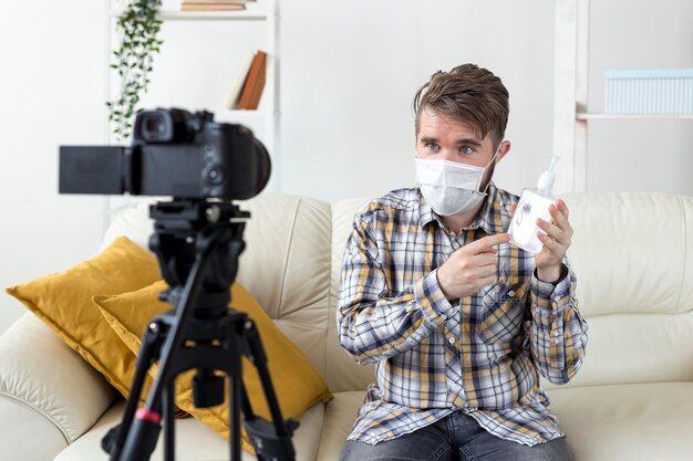 Vlogger recording video at home with hand sanitizer