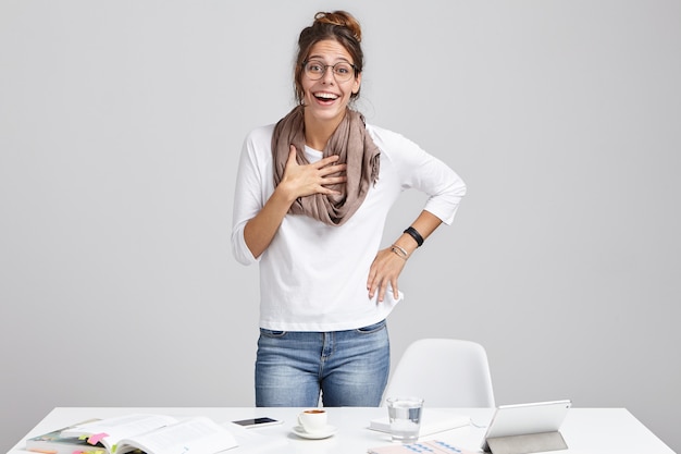 Vocation and creativity. Cheerful young successful talented woman designer wearing scarf and glasses standing