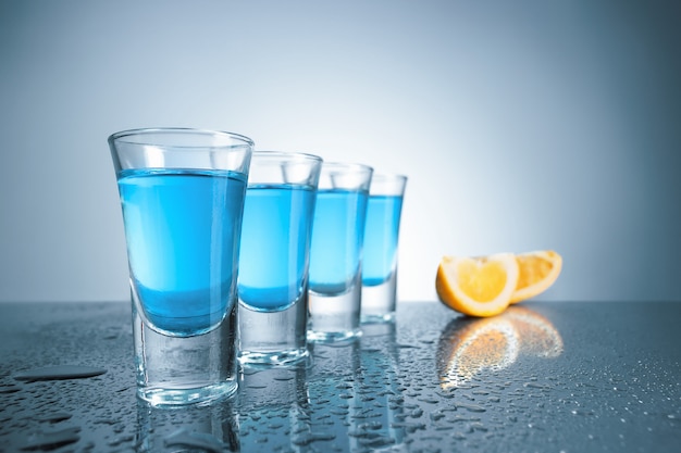 Free photo vodka glass with ice on blue