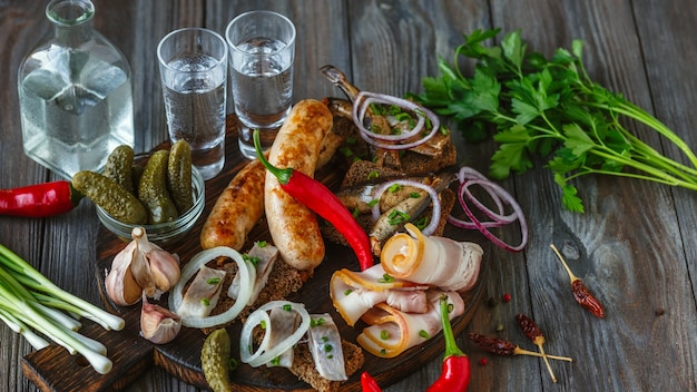 Free photo vodka and traditional snack on wooden wall