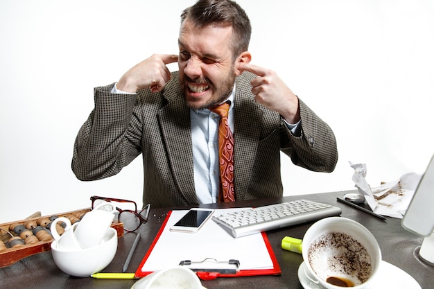 Free photo voices in his head. young man suffering from the colleagues' talks in the office. can't concentrate and working in the silence. concept of office worker's troubles, business, problems and stress.