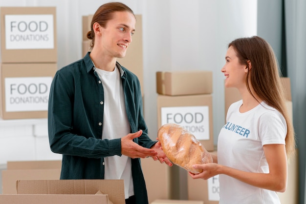 Volunteer for food donation giving out bread to person in need