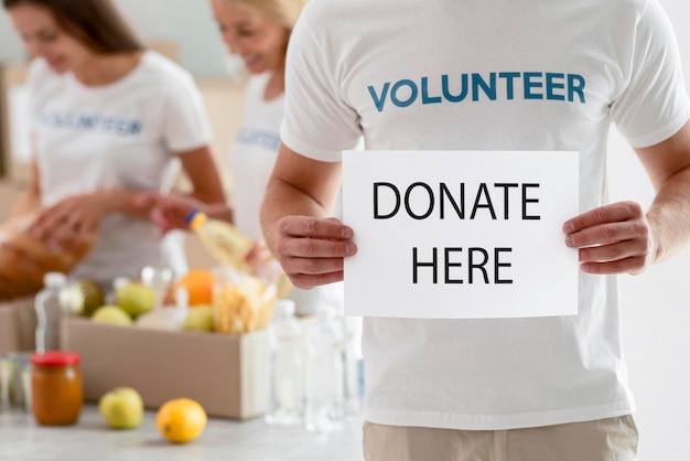 Volunteer holding placard with instructions for donation