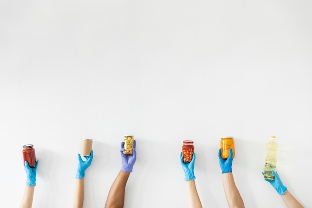 Volunteer's hands with gloves holding provisions for donation