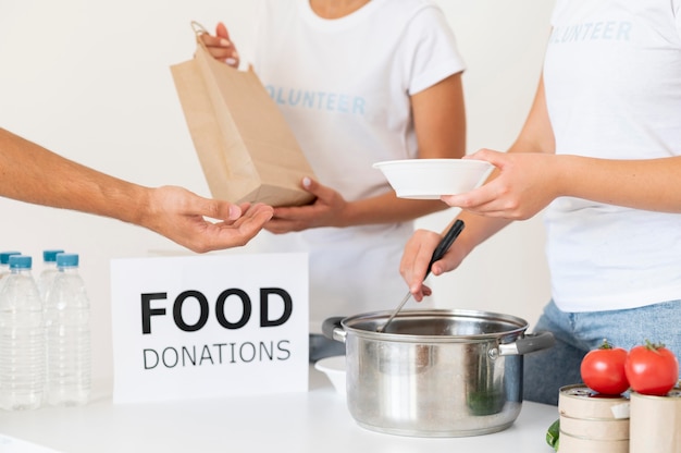 Free photo volunteers handing donation food