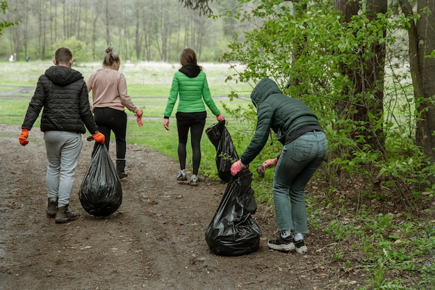 Free photo volunteers with garbage bags on a trip to nature, clean the environment.