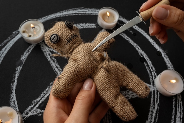 Free photo voodoo doll and candles high angle