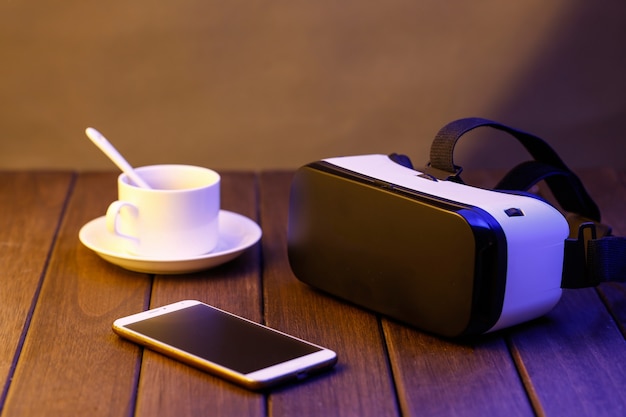 Free photo vr glasses and cell phone on wooden desk