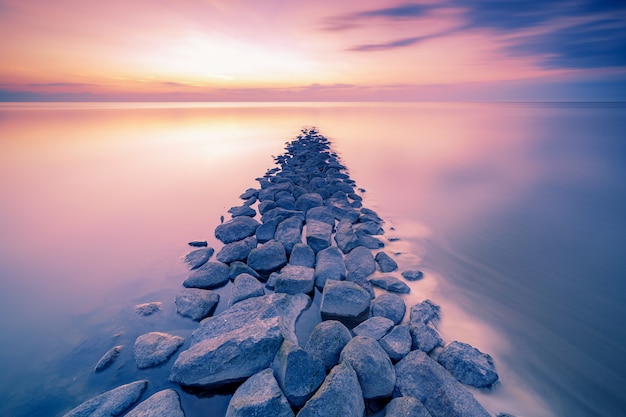 Free photo waddenzee or wadd sea during sunset seen from jettywith stones ferry in dutch province of friesland