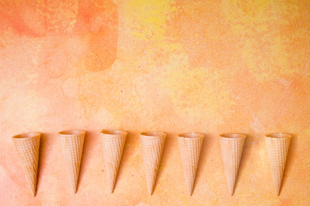 Waffle cones in row on multicolored background