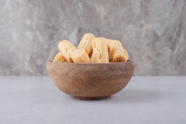 Waffle rolls in a bowl on marble table.