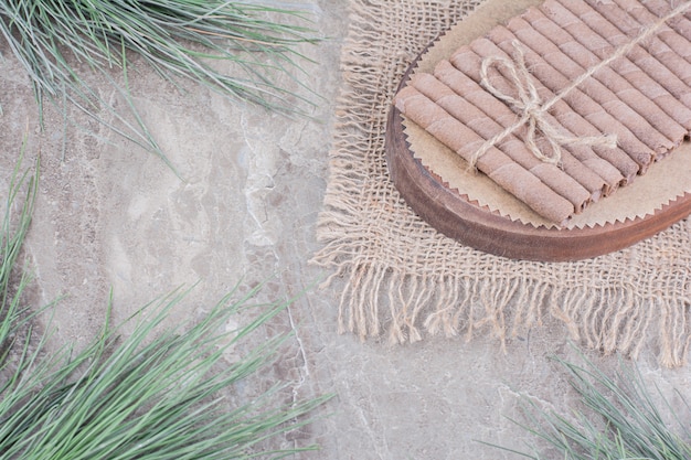 Free photo waffle sticks wrapped with a thread on a wooden board