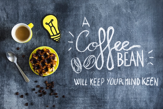 Free photo waffles with chocolate; coffee cup and paper cutout light bulb with text on chalkboard