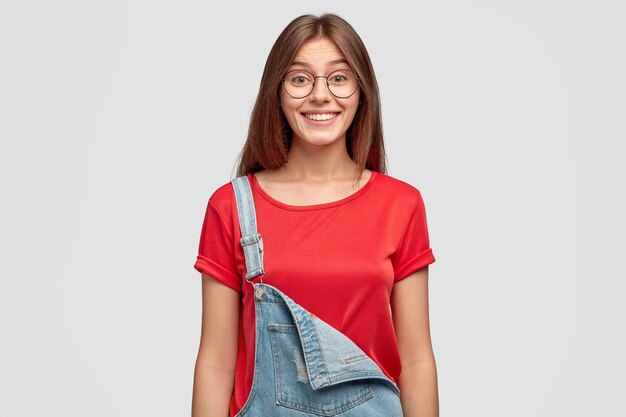 Waist up shot of fashionable girl with pleased facial expression