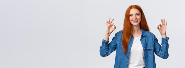 Free photo waistup portrait modern goodlooking redhead girl in casual shirt showing okay gestures and smiling n