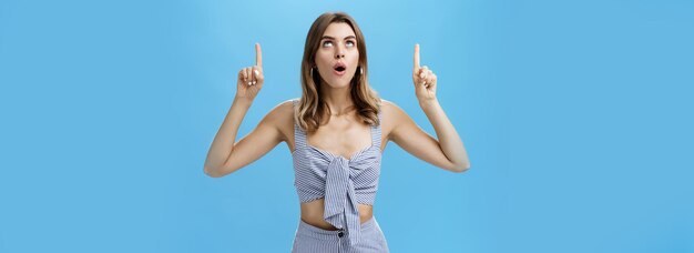 Waistup shot of curious goodlooking stylish modern woman dropping jaw saying wow while lifting head