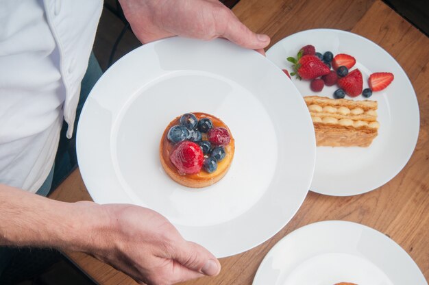 Waiter bringing fruit dessert