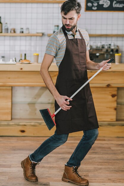 Waiter dancing with broom