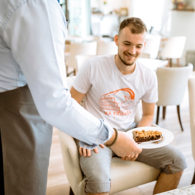 Free photo waiter serving cake