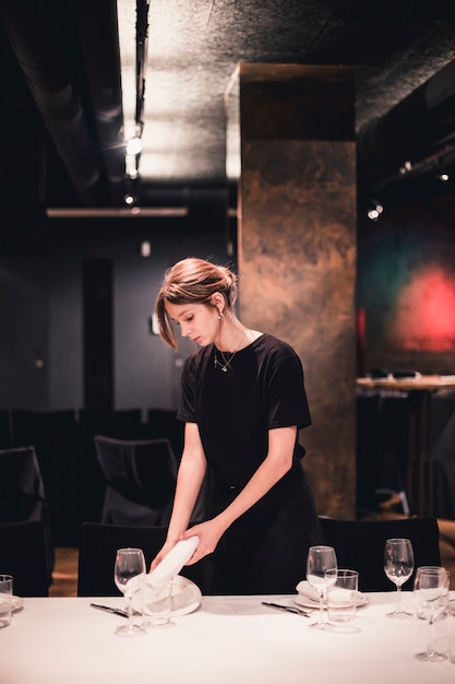 Waitress putting plate and napkin on table