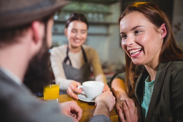 Free photo waitress serving a cup of coffee to customers