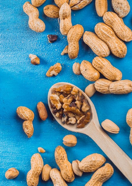 Walnut; peanuts and pistachio on blue textured background