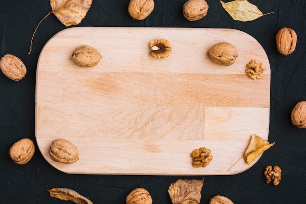 Free Photo walnuts and leaves around cutting board