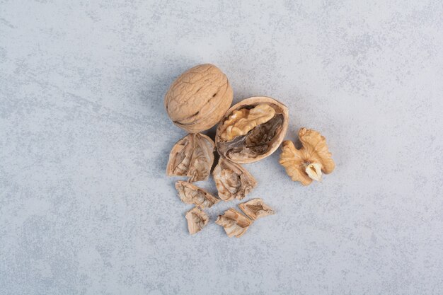 Walnuts and walnut kernels on stone surface