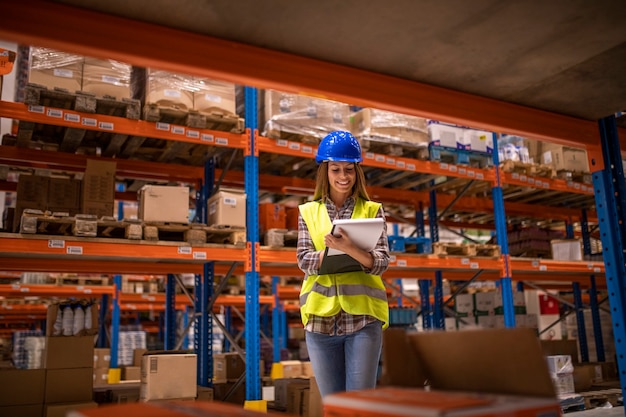 Warehouse female worker checking inventory in distribution warehouse