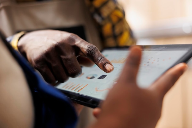 Warehouse worker hand pointing at inventory statistics on tablet