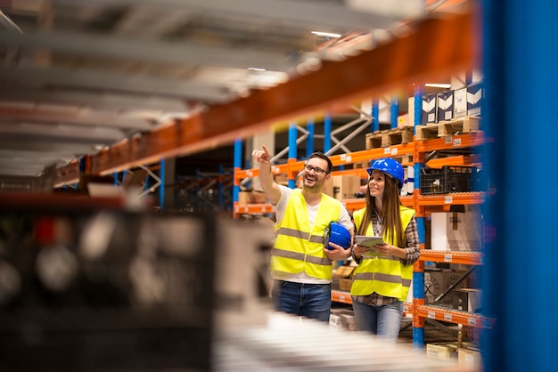 Free Photo warehouse workers checking inventory in large distribution warehouse storage