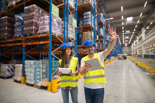 Free photo warehouse workers checking organization and distribution of products in large storage area