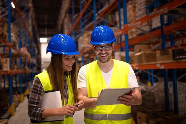 Warehouse workers checking shipment status on tablet computer