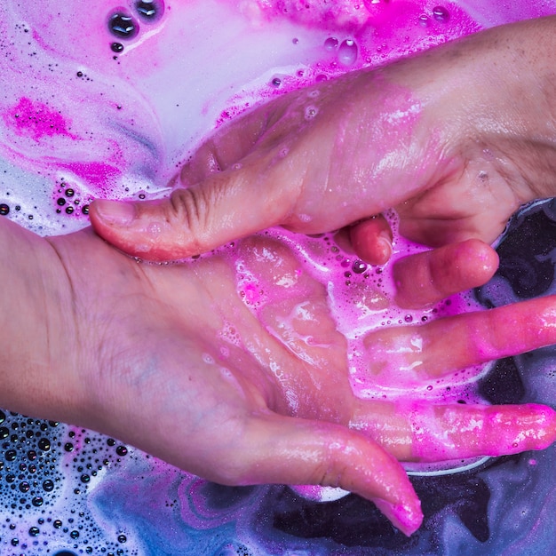 Washing hands in blue liquid 