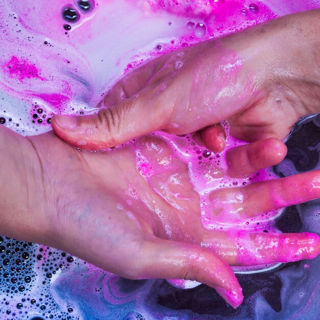 Washing hands in blue liquid 