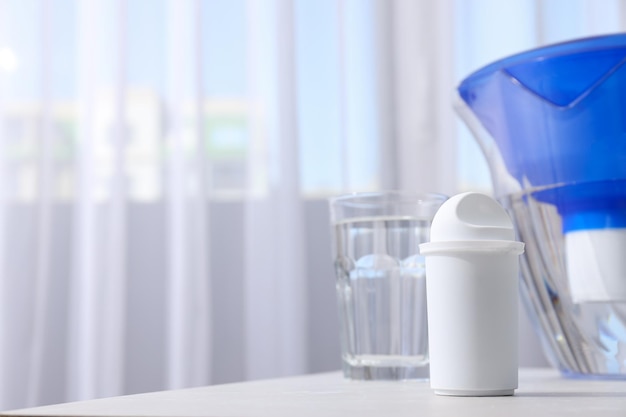 A water filter with a glass on a light background