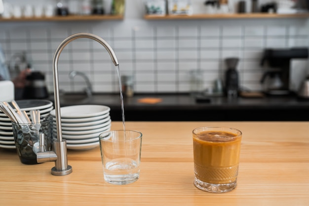 Water is pouring from a tap into a glass