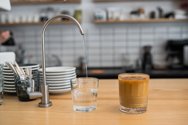 Water is pouring from a tap into a glass