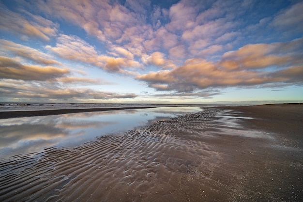 Free photo water pond on the seashore under a blue cloudy sky