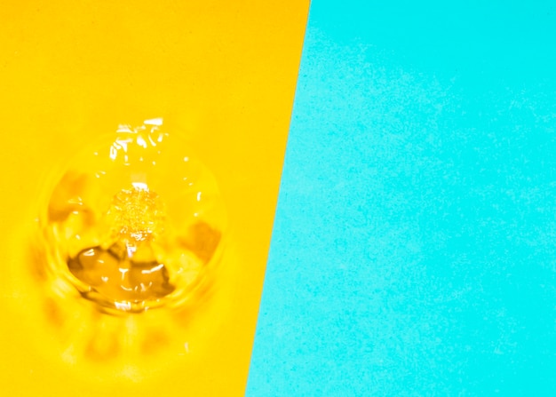 Water splash and bubbles on yellow and blue background