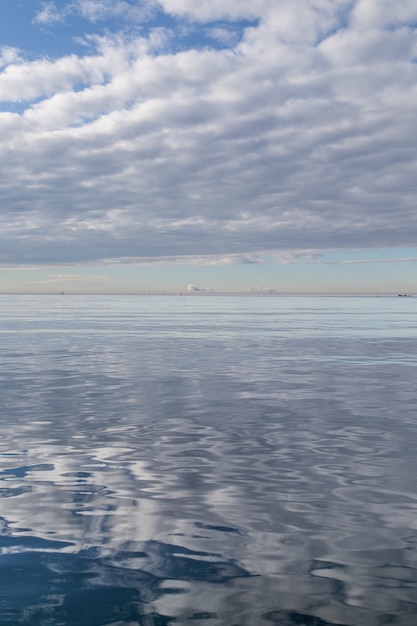 Free photo water surface reflecting the white cloudy sky