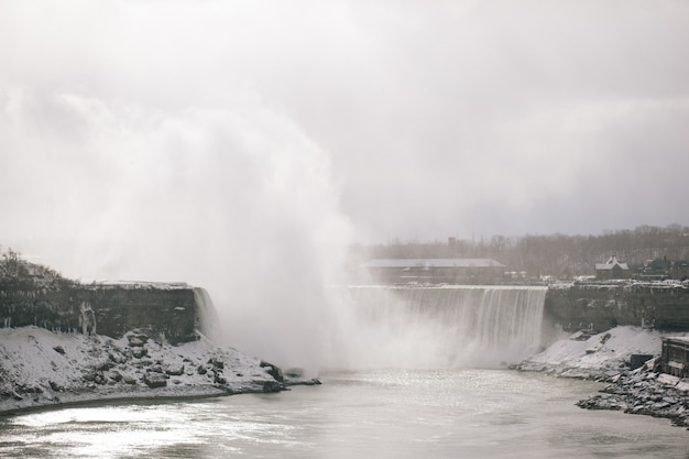 Waterfall in winter with trees in the background in Niagara Falls in Ontario Canada