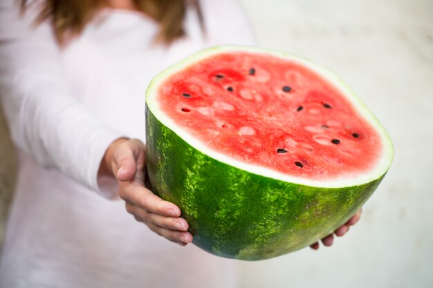 Watermelon in the hands of the girl close-up