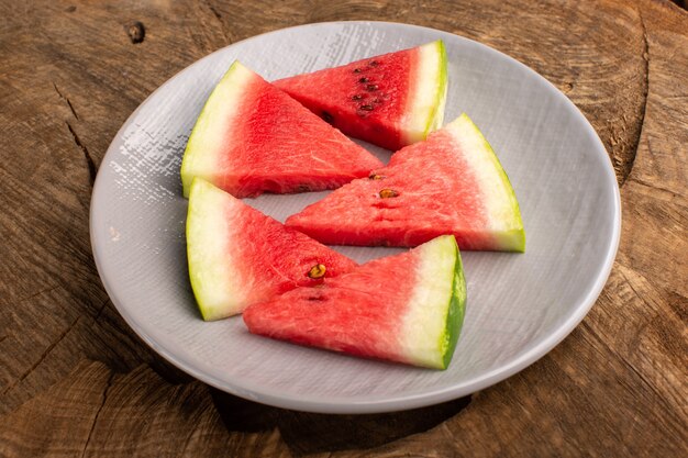 watermelon slices fresh and mellow pieces inside plate on brown