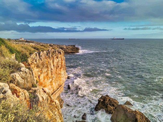 Free photo waves hitting rocks in cascais beach