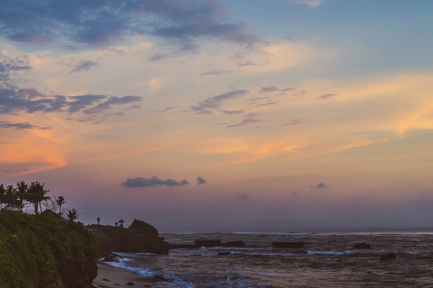 Free photo the waves of the ocean are breaking against the rocks. splashing ocean waves at sunset.