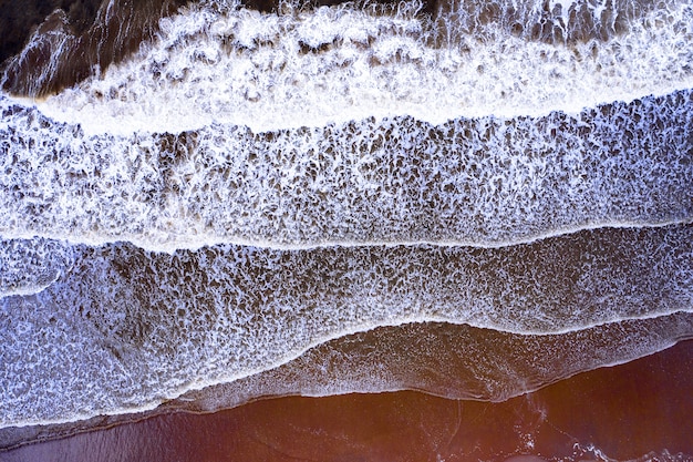 Waves with foamed water in the beach