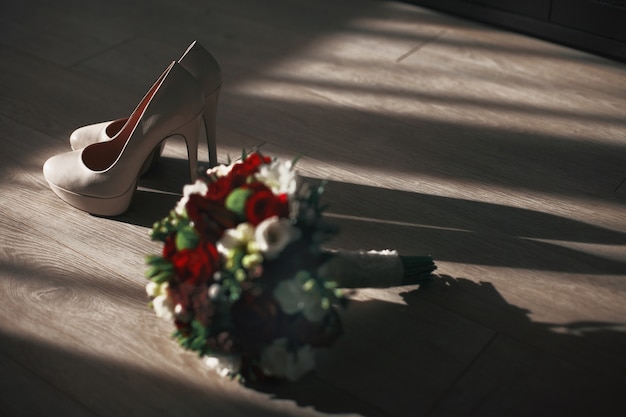 The wedding bouquet stands near shoes